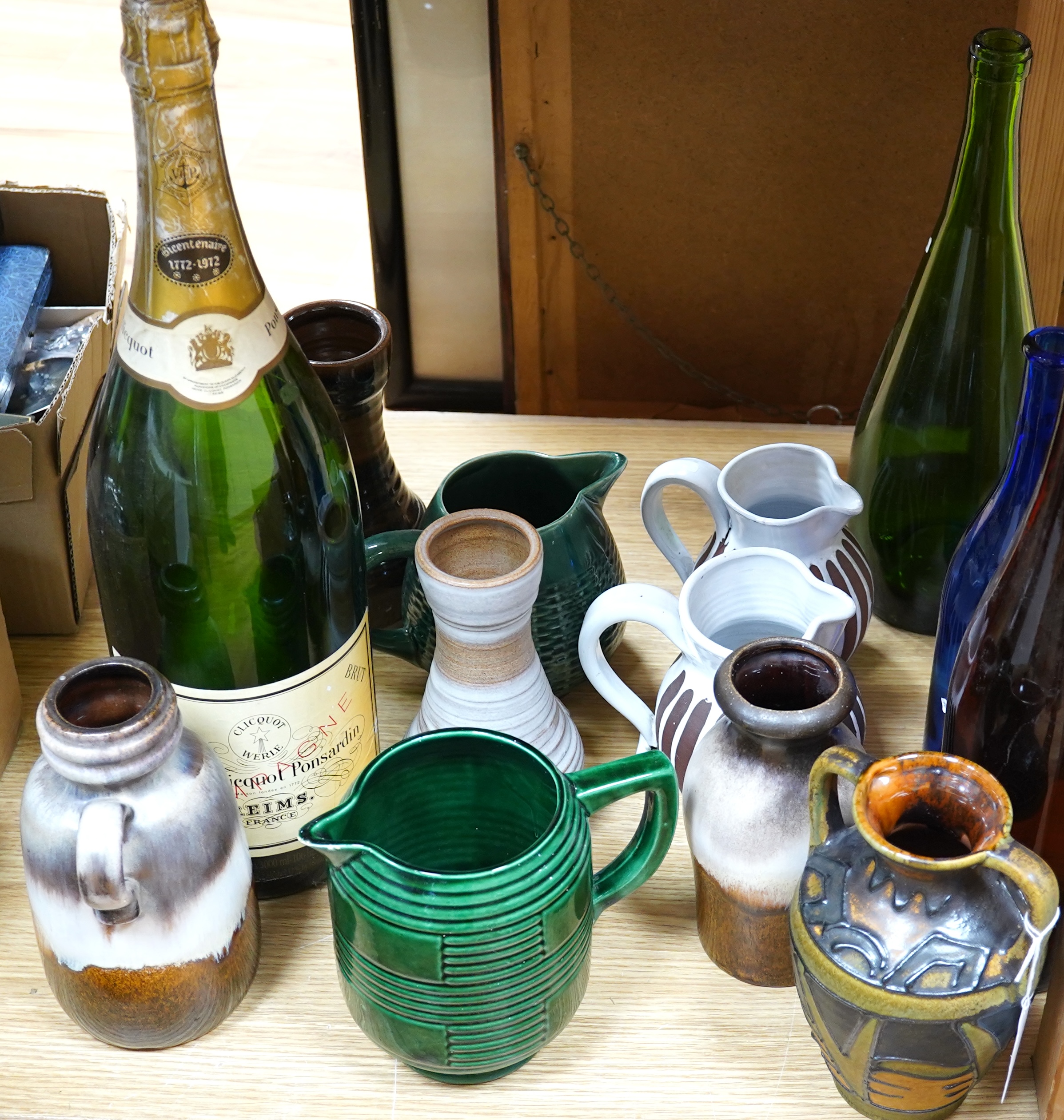 A collection of studio pottery and four glass bottles to include an oversized advertising bottle of Veuve Clicquot Ponsardin - 55cm high. Condition - fair to good